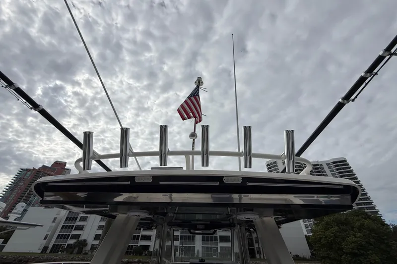 Slide: The Image of 2022 Pursuit S 358 Sport boat with American flag against cloudy sky backdrop. - 98