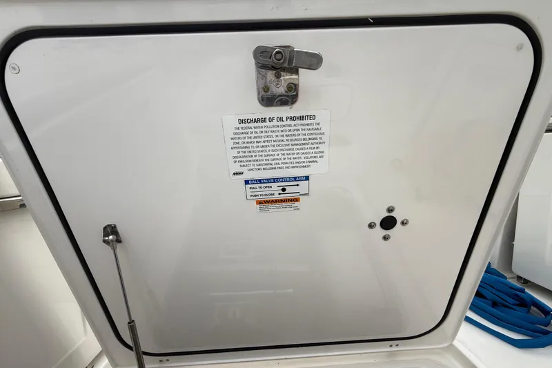 Slide: The Image of 2022 Pursuit S 358 Sport boat hatch with oil discharge warning label. - 99