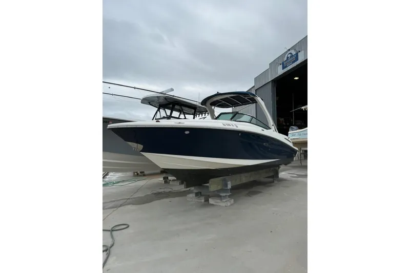 The Image of 2011 Sea Ray 250 SLX boat on dry dock, overcast sky background. - 0