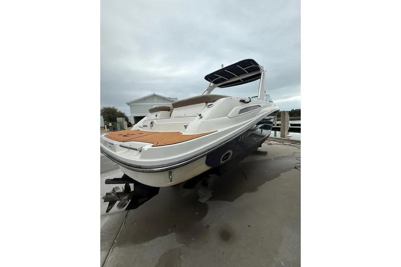 Slide: The Image of 2011 Sea Ray 250 SLX boat docked, featuring sleek design and spacious deck. - 13