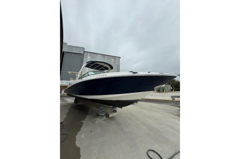 Slide: The Image of 2011 Sea Ray 250 SLX boat on dry dock, overcast sky background. - 2