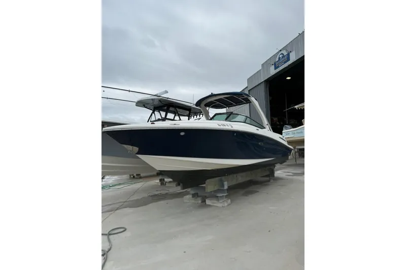 Slide: The Image of 2011 Sea Ray 250 SLX boat on dry dock, overcast sky background. - 21