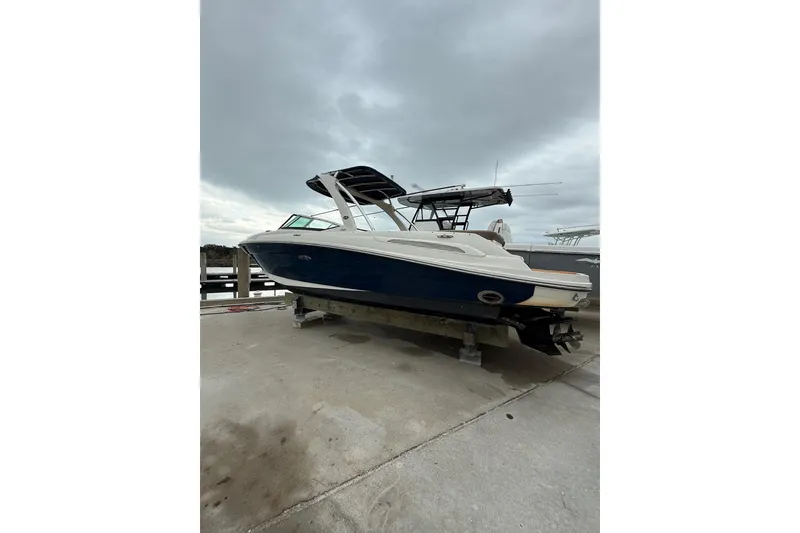 Slide: The Image of 2011 Sea Ray 250 SLX boat on a dock under cloudy skies. - 23
