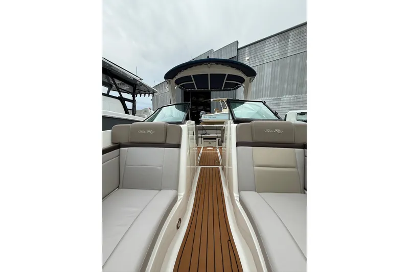 Slide: The Image of 2011 Sea Ray 250 SLX boat with sleek interior and wooden deck, docked near other vessels. - 9