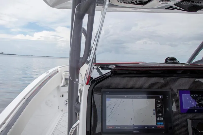 Slide: The Image of 2023 Nor-Tech 390 Sport Center Console dashboard with dual Garmin displays and steering wheel. - 23