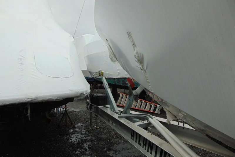 Slide: The Image of 2023 Nor-Tech 390 Sport Center Console boat with visible hull damage on trailer. - 3
