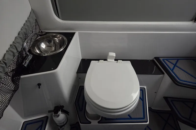 Slide: The Image of 2023 Nor-Tech 390 Sport Center Console interior with toilet and sink. - 30