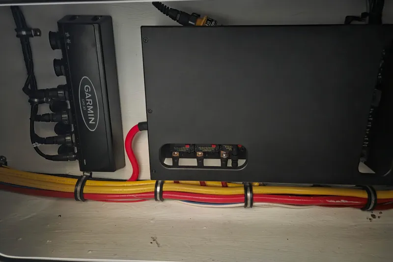 Slide: The Image of Electrical components and wiring inside a 2023 Nor-Tech 390 Sport Center Console boat. - 47