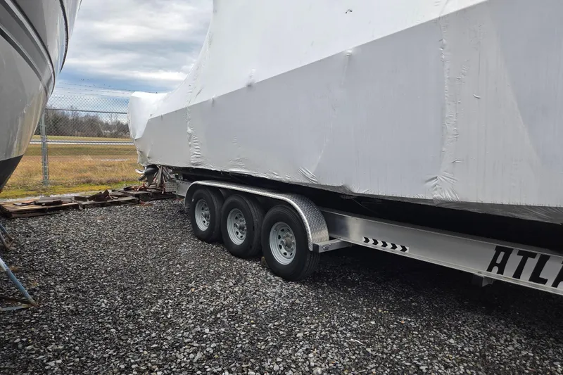 Slide: The Image of 2023 Nor-Tech 390 Sport Center Console boat covered on a trailer, parked outdoors. - 62