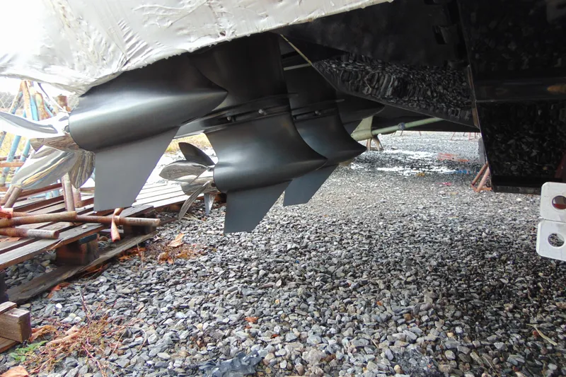 Slide: The Image of Propellers of 2023 Nor-Tech 390 Sport Center Console on gravel surface. - 7