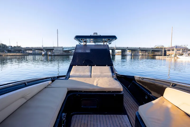 Slide: The Image of 2020 Zar Formenti 95 SL boat interior with cushioned seating, docked near a bridge. - 25