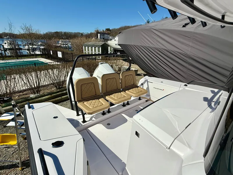 Slide: The Image of 2021 Axopar 37 boat with beige seating, docked near a pool and marina. - 10