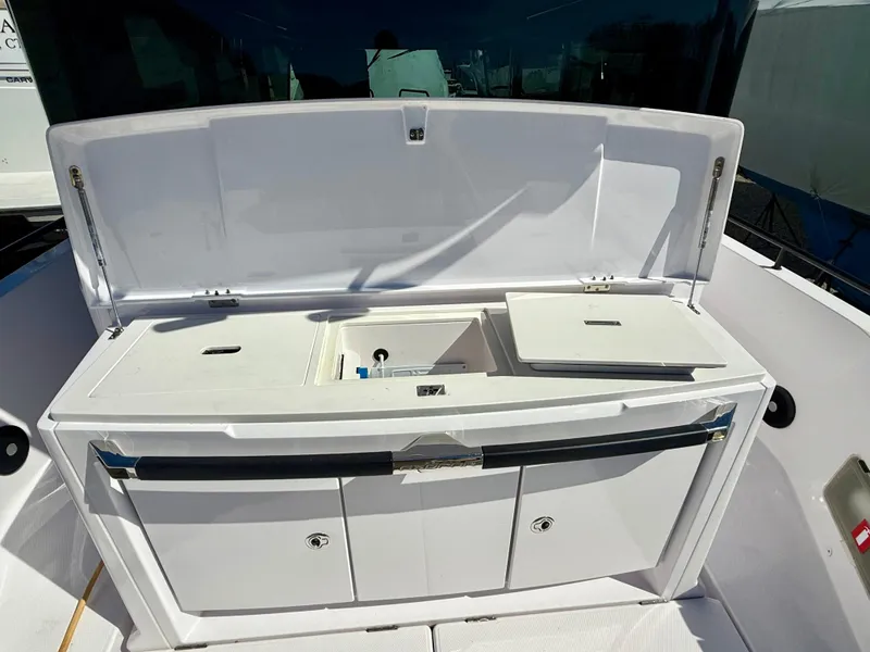 Slide: The Image of 2021 Axopar 37 boat with open storage compartment and sink on deck. - 11
