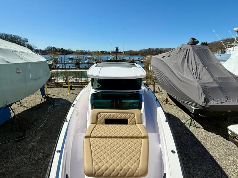 Slide: The Image of 2021 Axopar 37 boat docked, featuring a sleek design and spacious seating area. - 15