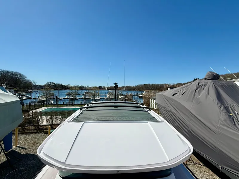 Slide: The Image of 2021 Axopar 37 boat docked near a marina under a clear blue sky. - 16