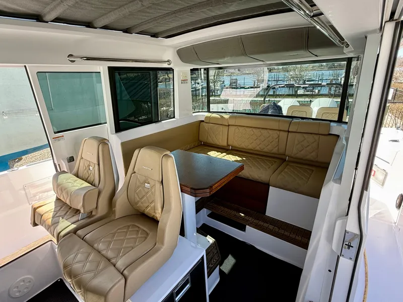 Slide: The Image of Luxurious interior of 2021 Axopar 37 boat with tan leather seating and dining area. - 19