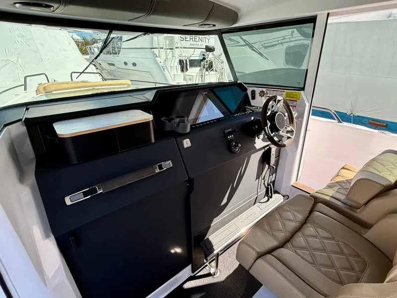 Slide: The Image of 2021 Axopar 37 boat interior with modern dashboard and comfortable seating. - 21