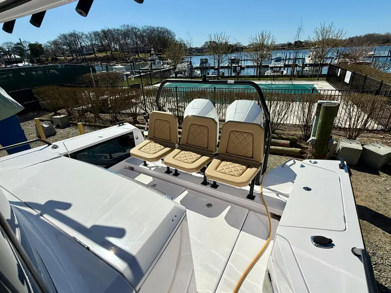 Slide: The Image of 2021 Axopar 37 boat with beige seating, docked near a marina under clear skies. - 9