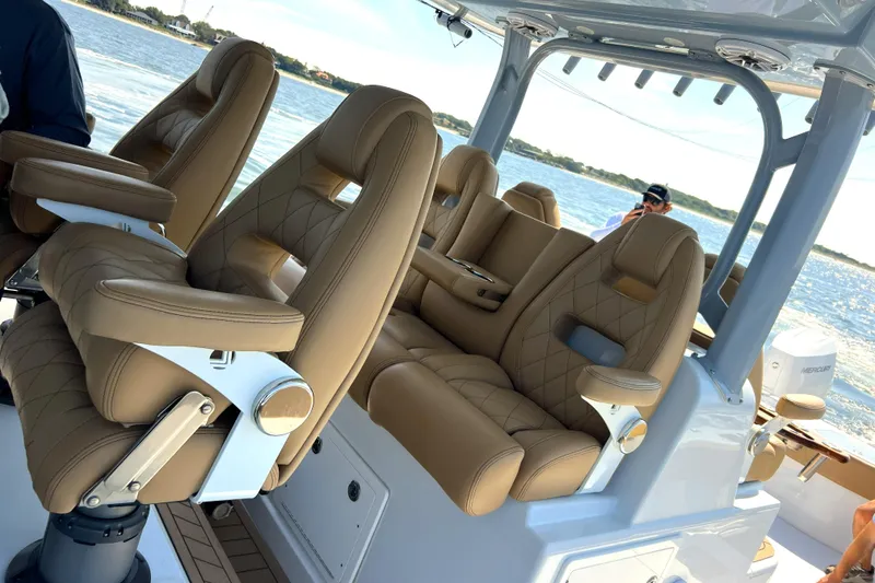 Slide: The Image of Luxurious seating on a 2026 Freeman 47 boat, featuring tan leather and ocean backdrop. - 10