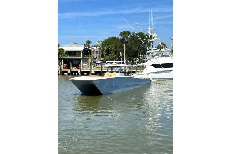 Slide: The Image of 2026 Freeman 47 boat docked in a marina, clear sky, calm water. - 2