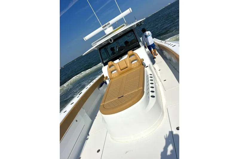 Slide: The Image of 2026 Freeman 47 boat cruising on open water, featuring tan seating and modern design. - 8