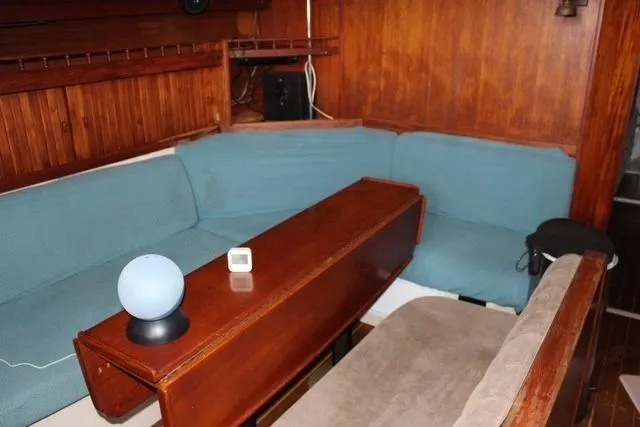 Slide: The Image of Interior of 1989 Catalina 42 sailboat with wooden table and blue seating. - 13