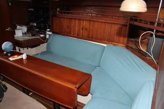 Slide: The Image of Interior of 1989 Catalina 42 sailboat with wooden table and blue cushioned seating. - 16