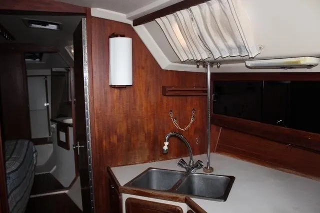 Slide: The Image of Interior of a 1989 Catalina 42 sailboat featuring a compact kitchen area. - 17