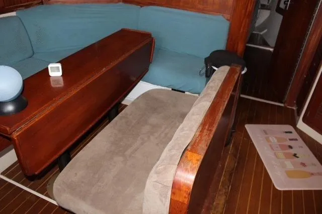 Slide: The Image of Interior of 1989 Catalina 42 sailboat with wooden table and cushioned seating. - 24