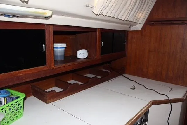 Slide: The Image of Interior of 1989 Catalina 42 sailboat with wooden cabinets and storage compartments. - 26