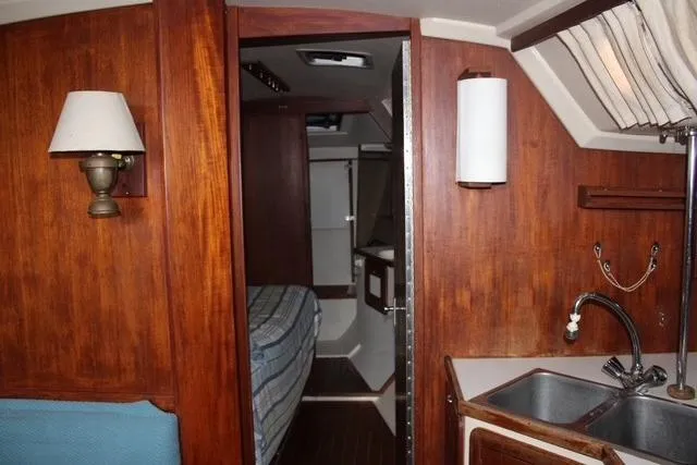 Slide: The Image of Interior of 1989 Catalina 42 sailboat with wood paneling and compact kitchen area. - 27