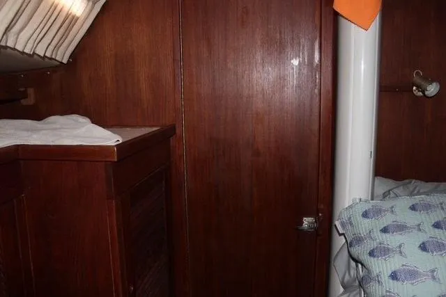 Slide: The Image of Interior of 1989 Catalina 42 sailboat with wooden cabinetry and cozy bedding. - 28