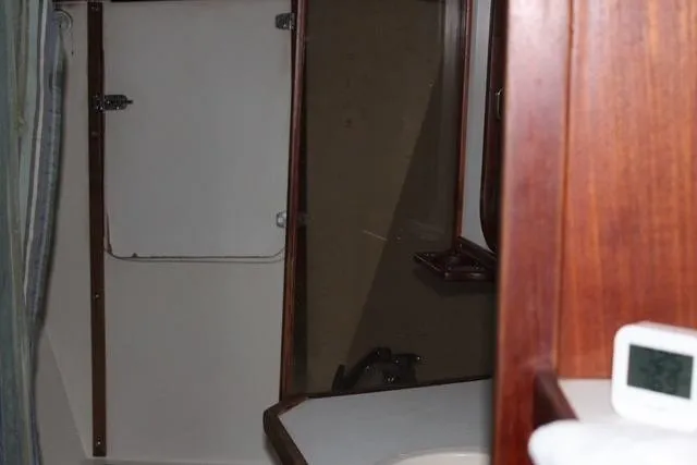 Slide: The Image of Interior of 1989 Catalina 42 sailboat bathroom with wooden accents and compact design. - 31