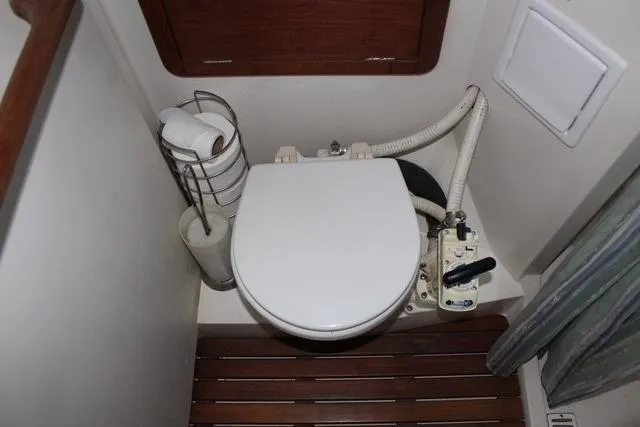 Slide: The Image of 1989 Catalina 42 yacht bathroom with marine toilet and wooden floor. - 35