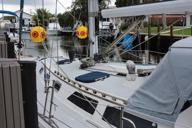 Slide: The Image of 1989 Catalina 42 sailboat docked, featuring deck details and rigging in a marina setting. - 36