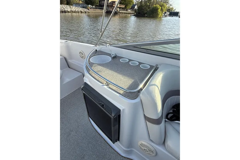Slide: The Image of 2003 Four Winns 285 Sundowner boat interior with seating and cup holders by the water. - 6