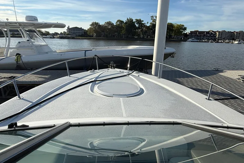Slide: The Image of 2003 Four Winns 285 Sundowner boat docked at a marina with scenic waterfront view. - 7