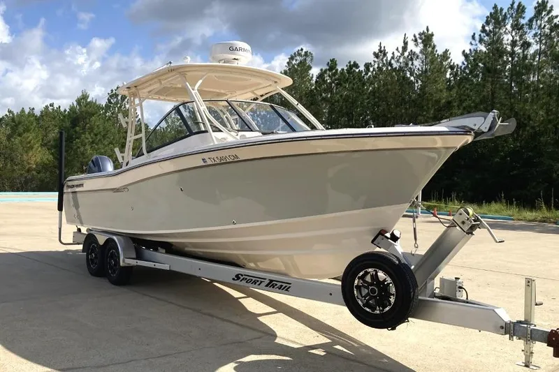 The Image of 2015 Grady-White Freedom 275 boat on trailer, parked outdoors under cloudy sky. - 0