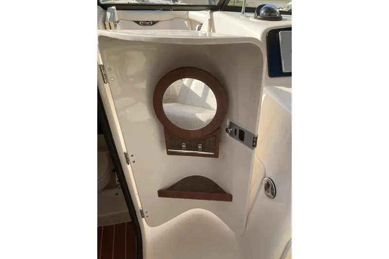 Slide: The Image of 2015 Grady-White Freedom 275 boat interior with mirror and storage shelf. - 16