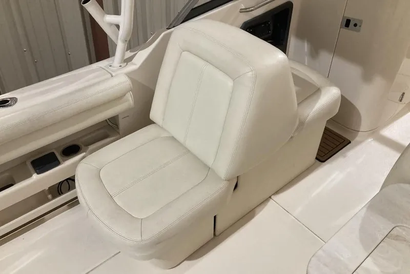 Slide: The Image of 2015 Grady-White Freedom 275 boat interior with white seating and storage compartments. - 21