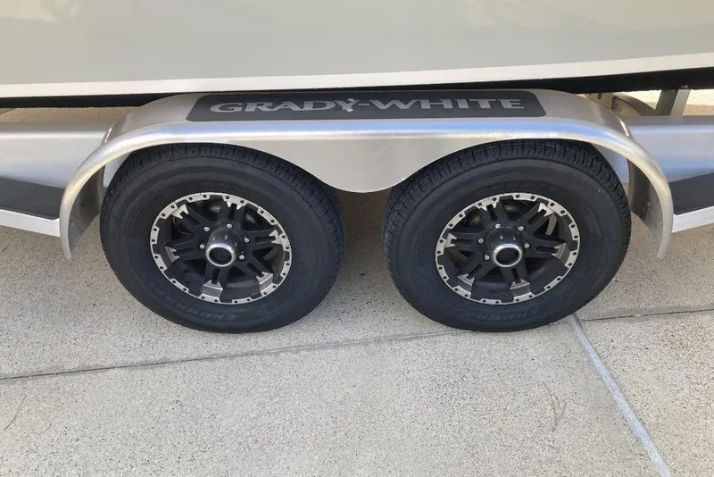 Slide: The Image of Trailer wheels of a 2015 Grady-White Freedom 275 boat on concrete surface. - 24