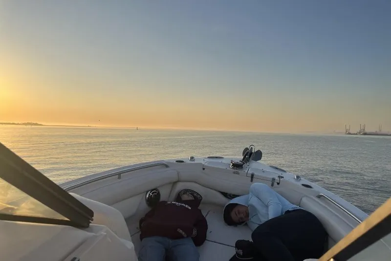 Slide: The Image of 2015 Grady-White Freedom 275 boat at sunrise with two people relaxing onboard. - 5