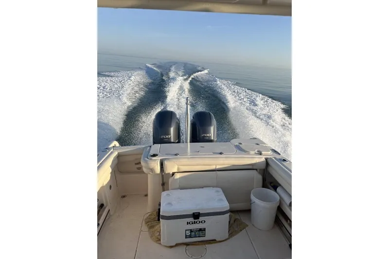 Slide: The Image of 2015 Grady-White Freedom 275 boat cruising on calm waters, rear view. - 6