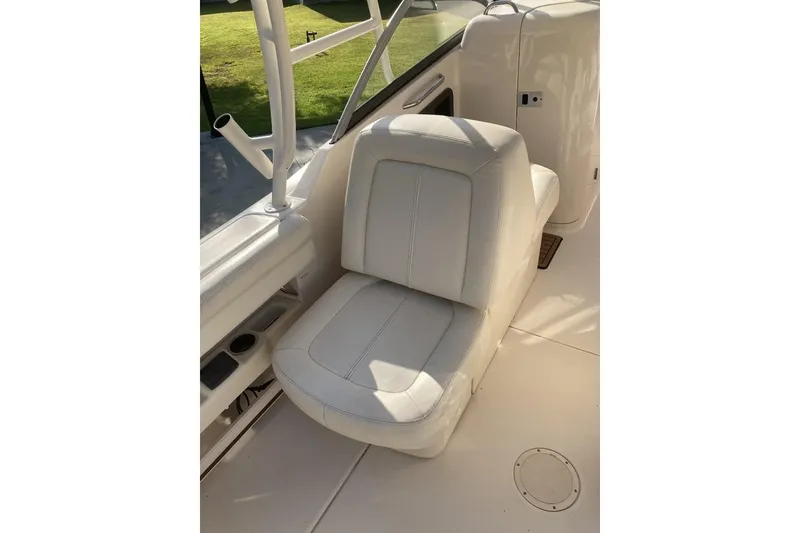 Slide: The Image of Grady-White Freedom 275 boat seat, 2015 model, featuring white upholstery and cup holders. - 8