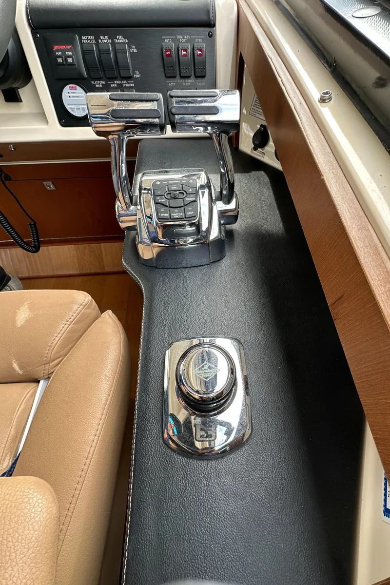 Slide: The Image of Control panel of a 2014 Sea Ray 510 Sundancer yacht, featuring throttle and joystick. - 29