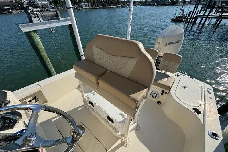 Slide: The Image of 2024 Scout 231 XSB boat interior with Mercury engine, featuring beige seating and steering wheel. - 12