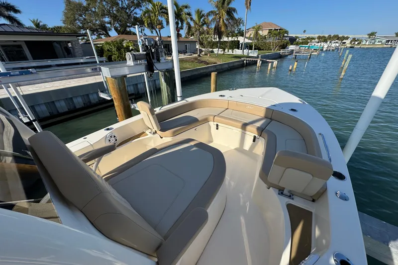 Slide: The Image of 2024 Scout 231 XSB boat with spacious seating, docked by a serene waterfront. - 16