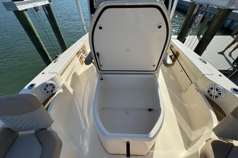 Slide: The Image of 2024 Scout 231 XSB boat interior with open storage compartment, dockside view. - 21