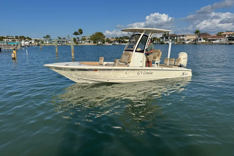 Slide: The Image of 2024 Scout 231 XSB boat on calm water, clear sky, coastal background. - 4