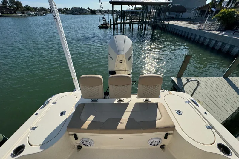 Slide: The Image of 2024 Scout 231 XSB boat with seating and Mercury engine, docked by a sunny waterfront. - 7